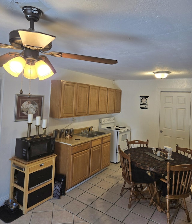 662 Avenida Perea, Bernalillo, NM 87004 - kitchen with white range with electric cooktop, black microwave, ceiling fan, and light tile patterned floors
