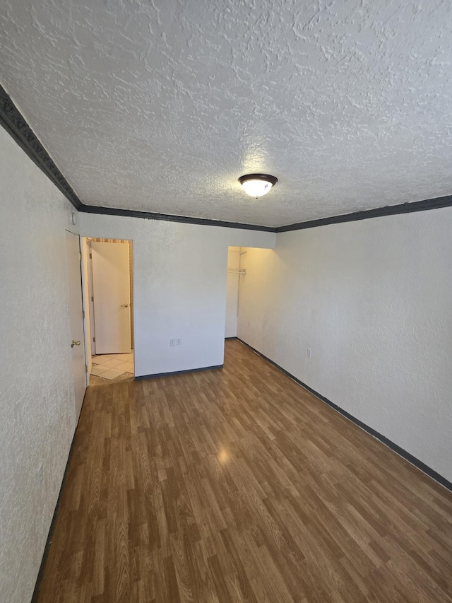 662 Avenida Perea, Bernalillo, NM 87004 - unfurnished bedroom featuring wood finished floors, a textured ceiling, a textured wall, and crown molding