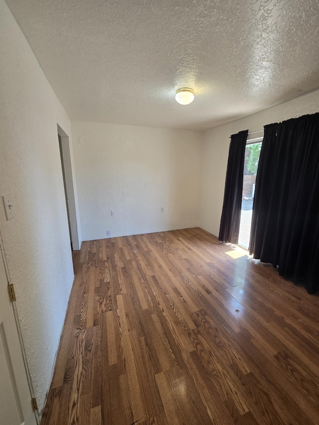 662 Avenida Perea, Bernalillo, NM 87004 - empty room with wood finished floors, a textured ceiling, and a textured wall