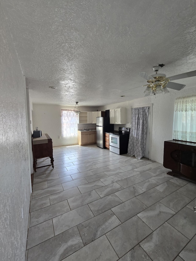 662 Avenida Perea, Bernalillo, NM 87004 - kitchen featuring stainless steel appliances, a textured ceiling, a textured wall, a ceiling fan, and open floor plan