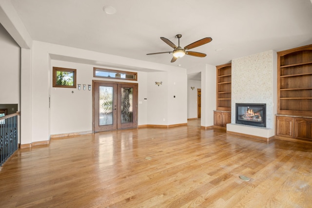 2632 Globe Ct NE, Rio Rancho, NM 87124 - unfurnished living room featuring built in features, a fireplace, light wood-type flooring, and a ceiling fan