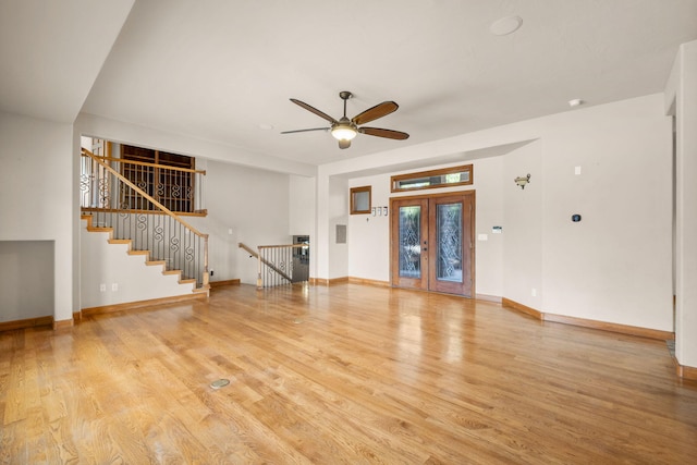 2632 Globe Ct NE, Rio Rancho, NM 87124 - unfurnished living room with light wood-type flooring, a ceiling fan, stairway, and french doors
