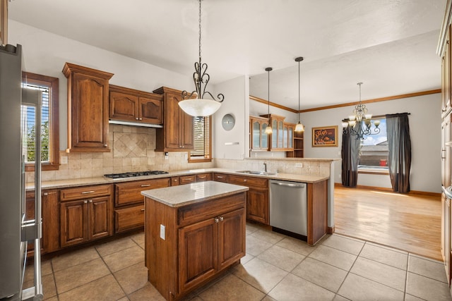 2632 Globe Ct NE, Rio Rancho, NM 87124 - kitchen featuring stainless steel appliances, a peninsula, tasteful backsplash, a chandelier, and a center island