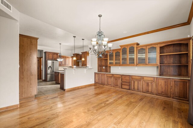 2632 Globe Ct NE, Rio Rancho, NM 87124 - kitchen featuring stainless steel fridge, a peninsula, a chandelier, brown cabinetry, and light countertops