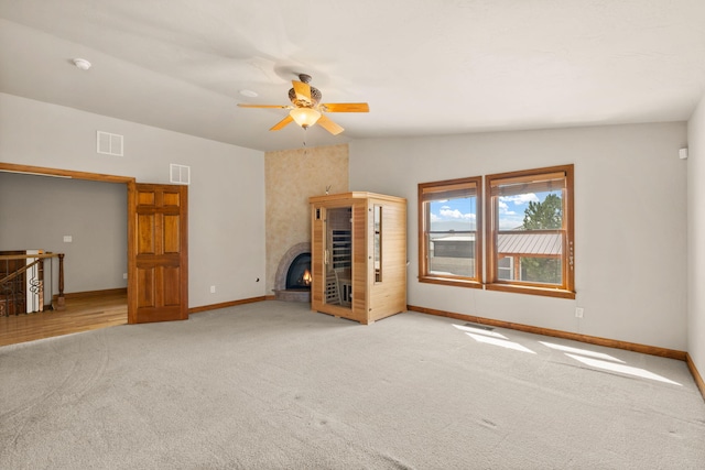 2632 Globe Ct NE, Rio Rancho, NM 87124 - unfurnished living room with carpet flooring, a ceiling fan, and a glass covered fireplace