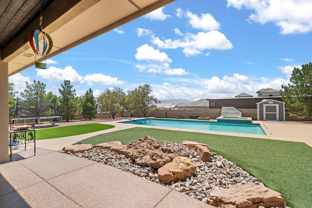 2632 Globe Ct NE, Rio Rancho, NM 87124 - view of swimming pool with a trampoline, a storage unit, a patio, a fenced backyard, and a pool with connected hot tub