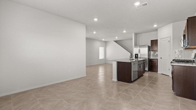 5623 Sagan Loop SE, Albuquerque, NM 87106 - kitchen featuring stainless steel appliances, open floor plan, a kitchen island with sink, dark brown cabinetry, and recessed lighting