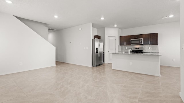 5623 Sagan Loop SE, Albuquerque, NM 87106 - kitchen with appliances with stainless steel finishes, open floor plan, recessed lighting, dark brown cabinetry, and a kitchen island with sink