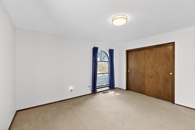 5207 Russell Dr NW, Albuquerque, NM 87114 - unfurnished bedroom with carpet flooring, a closet, and a textured ceiling