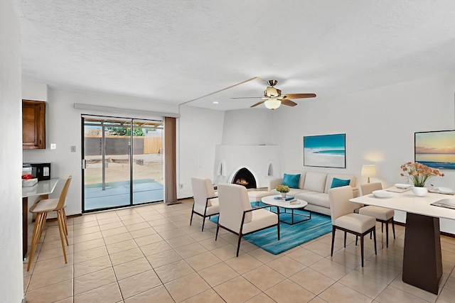 5207 Russell Dr NW, Albuquerque, NM 87114 - living area featuring light tile patterned floors, ceiling fan, a fireplace, and a textured ceiling