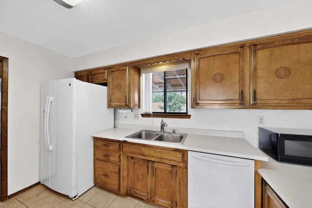 5207 Russell Dr NW, Albuquerque, NM 87114 - kitchen with white appliances, brown cabinetry, light countertops, and light tile patterned floors