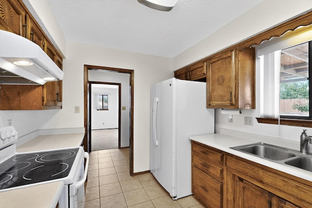 5207 Russell Dr NW, Albuquerque, NM 87114 - kitchen featuring white appliances, under cabinet range hood, light countertops, brown cabinets, and light tile patterned floors
