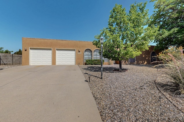 5207 Russell Dr NW, Albuquerque, NM 87114 - adobe home featuring concrete driveway, an attached garage, and stucco siding