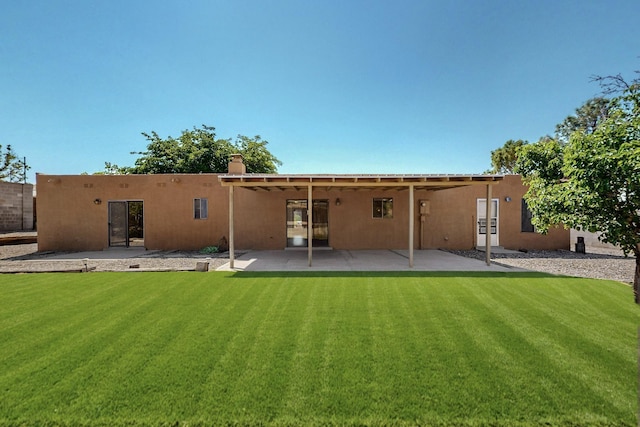 5207 Russell Dr NW, Albuquerque, NM 87114 - back of property with stucco siding, a yard, and a patio