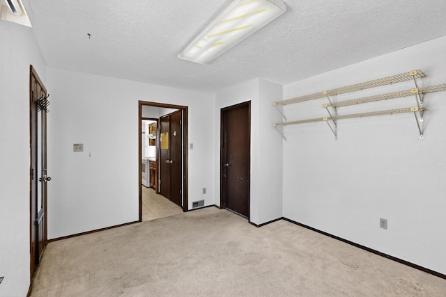 5207 Russell Dr NW, Albuquerque, NM 87114 - unfurnished bedroom with light carpet, a textured ceiling, and ensuite bath