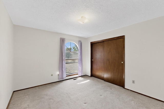 5207 Russell Dr NW, Albuquerque, NM 87114 - unfurnished bedroom with carpet floors, a closet, and a textured ceiling