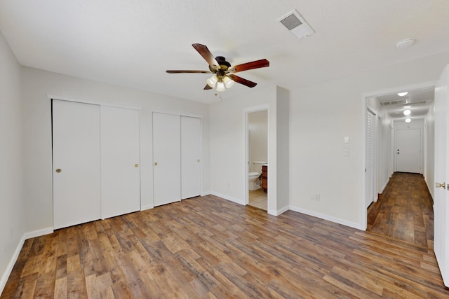 7408 Estes Park Ave NW, Albuquerque, NM 87114 - unfurnished bedroom featuring multiple closets, wood finished floors, attic access, ensuite bathroom, and a ceiling fan