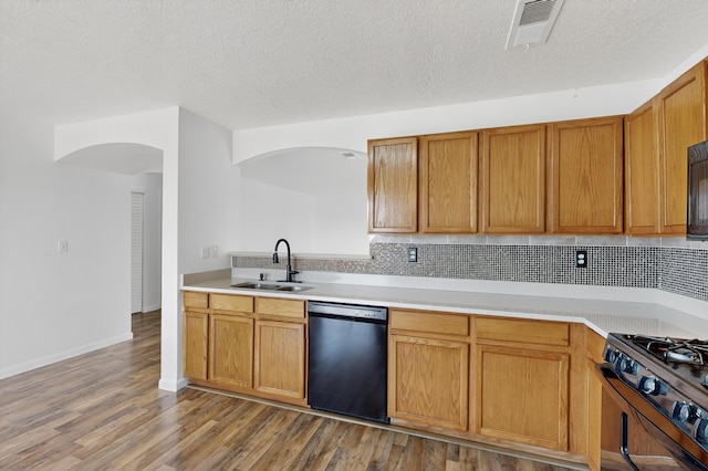 7408 Estes Park Ave NW, Albuquerque, NM 87114 - kitchen featuring black appliances, arched walkways, light countertops, decorative backsplash, and wood finished floors