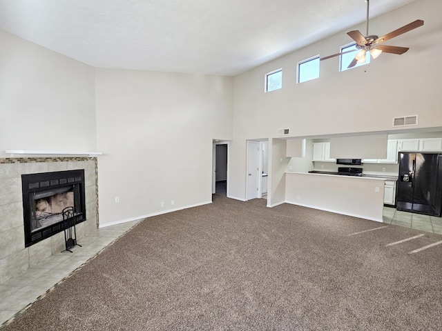 7235 Whippoorwill Ln NE, Albuquerque, NM 87109 - unfurnished living room with a towering ceiling, a ceiling fan, light colored carpet, and a tile fireplace