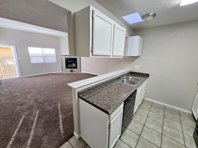 7235 Whippoorwill Ln NE, Albuquerque, NM 87109 - kitchen featuring dishwasher, white cabinets, a fireplace, light tile patterned floors, and a textured ceiling