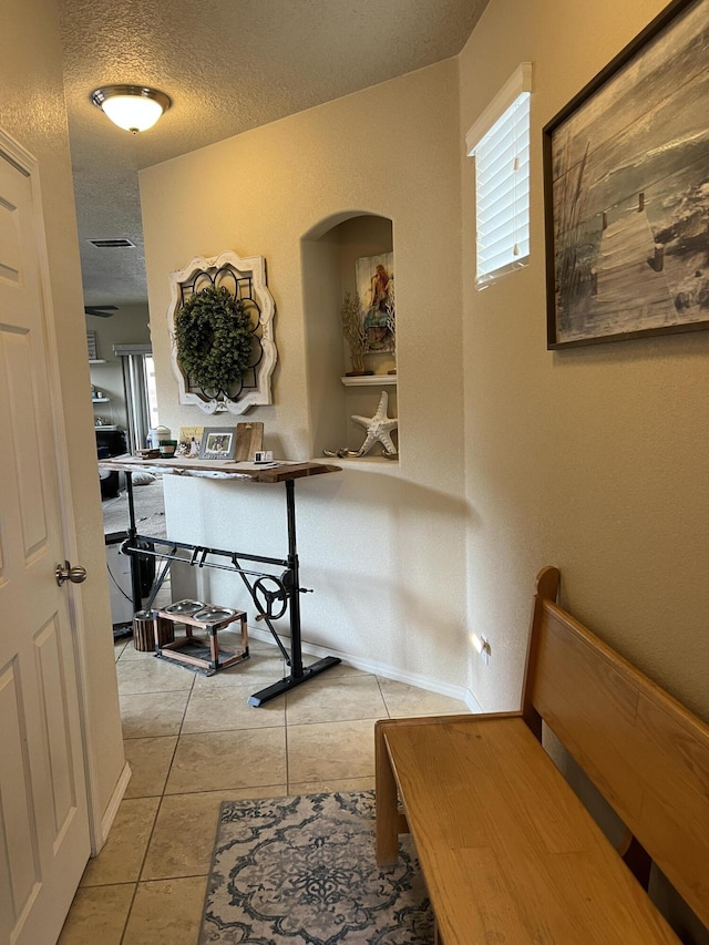 839 Serrano Pointe NW, Albuquerque, NM 87120 - corridor with a textured ceiling, light tile patterned floors, and arched walkways