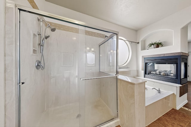 1128 San Augustin Dr, Bernalillo, NM 87004 - bathroom with a garden tub, a stall shower, a tiled fireplace, and tile patterned floors
