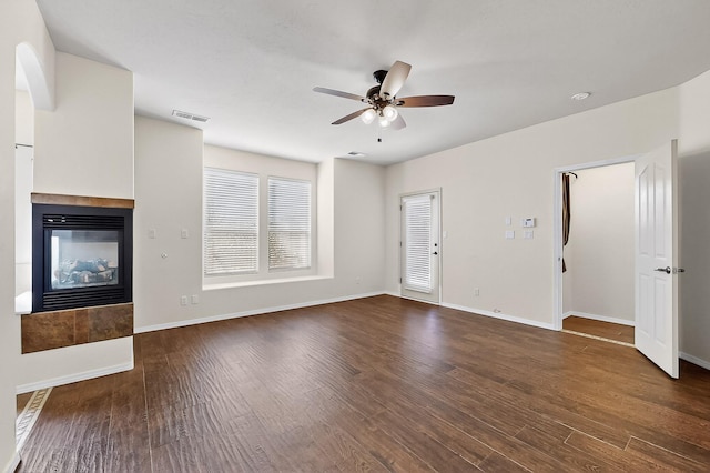 1128 San Augustin Dr, Bernalillo, NM 87004 - unfurnished living room featuring a ceiling fan, a tiled fireplace, and wood finished floors