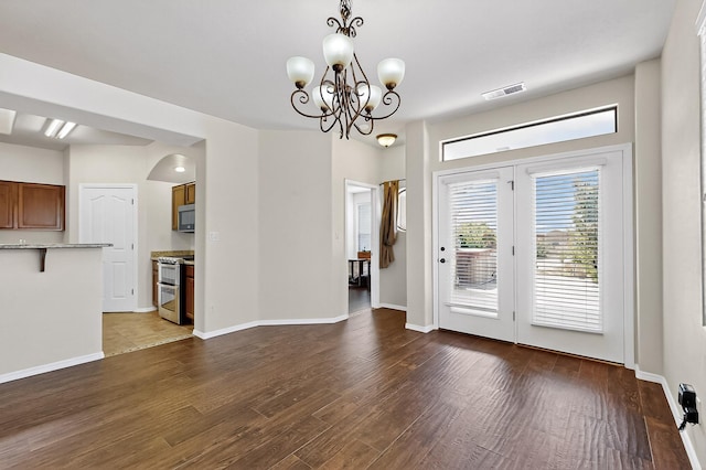1128 San Augustin Dr, Bernalillo, NM 87004 - unfurnished dining area featuring a chandelier, wood finished floors, and arched walkways