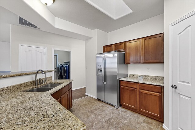 1128 San Augustin Dr, Bernalillo, NM 87004 - kitchen with high quality fridge, independent washer and dryer, a skylight, and light stone counters