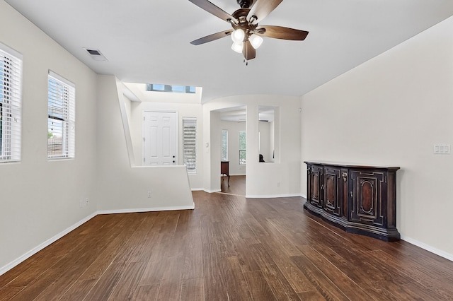 1128 San Augustin Dr, Bernalillo, NM 87004 - unfurnished living room featuring a ceiling fan, dark wood-style floors, and healthy amount of natural light