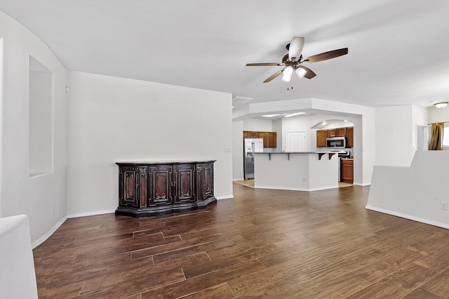 1128 San Augustin Dr, Bernalillo, NM 87004 - unfurnished living room with ceiling fan, dark wood-style floors, and arched walkways