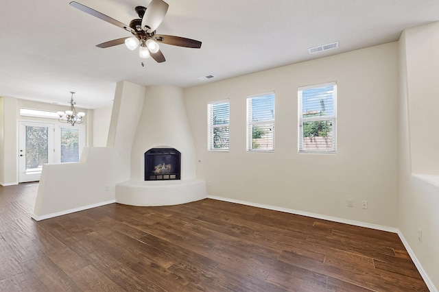 1128 San Augustin Dr, Bernalillo, NM 87004 - unfurnished living room featuring a chandelier, dark wood finished floors, plenty of natural light, and a fireplace