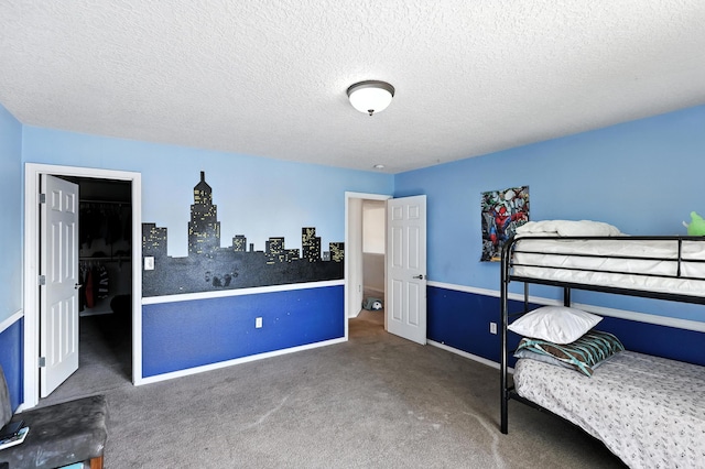 1230 Carrizo St NW, Los Lunas, NM 87031 - carpeted bedroom featuring a walk in closet and a textured ceiling