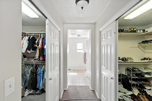 1230 Carrizo St NW, Los Lunas, NM 87031 - corridor with tile patterned floors, a textured ceiling, and carpet flooring