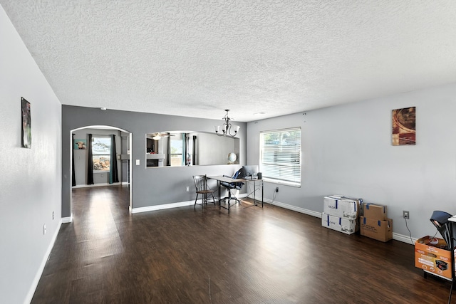 1230 Carrizo St NW, Los Lunas, NM 87031 - dining area featuring wood finished floors, arched walkways, a textured ceiling, and a chandelier