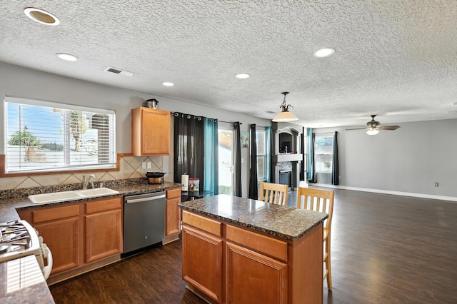 1230 Carrizo St NW, Los Lunas, NM 87031 - kitchen with stainless steel dishwasher, dark wood finished floors, healthy amount of natural light, a textured ceiling, and a ceiling fan