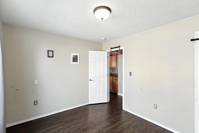 1230 Carrizo St NW, Los Lunas, NM 87031 - spare room with dark wood-type flooring and a textured ceiling