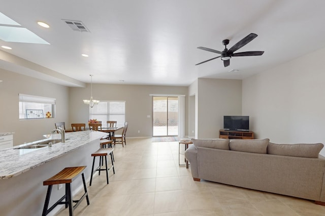 4813 Guadalupe Peak St SW, Los Lunas, NM 87031 - living area with recessed lighting, a ceiling fan, light tile patterned flooring, a skylight, and a chandelier