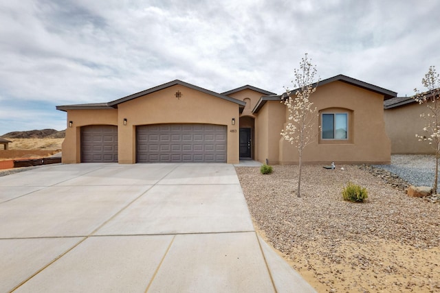 4813 Guadalupe Peak St SW, Los Lunas, NM 87031 - view of front of house with stucco siding, an attached garage, and concrete driveway