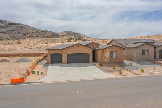 4813 Guadalupe Peak St SW, Los Lunas, NM 87031 - mediterranean / spanish-style house featuring an attached garage, stucco siding, concrete driveway, and a mountain view