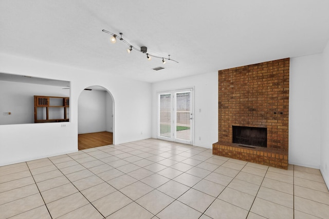 6940 Cherry Hills Loop NE, Albuquerque, NM 87111 - unfurnished living room with arched walkways, light tile patterned floors, and a fireplace
