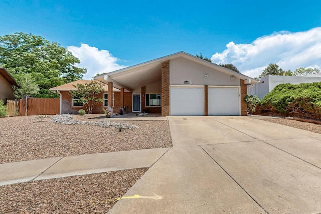 6940 Cherry Hills Loop NE, Albuquerque, NM 87111 - view of front of home featuring brick siding, an attached garage, and driveway
