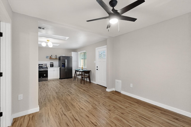 1259 8th St NW, Albuquerque, NM 87102 - living room with light wood-style floors, ceiling fan, and a skylight