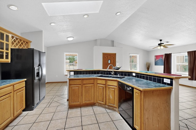 1259 8th St NW, Albuquerque, NM 87102 - kitchen with black appliances, a skylight, vaulted ceiling, light tile patterned floors, and a textured ceiling
