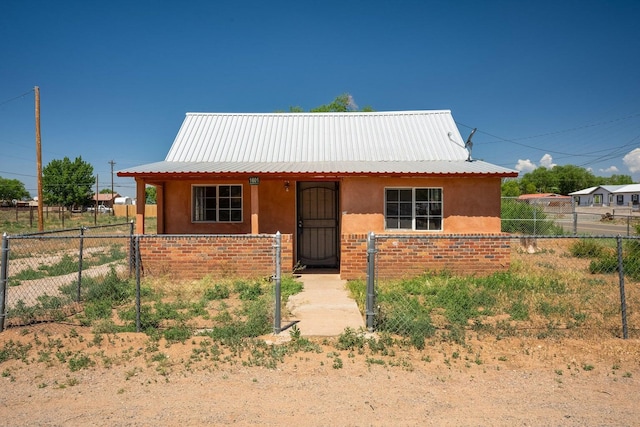1601 7th St, Moriarty, NM 87035 - bungalow-style house featuring stucco siding, covered porch, a gate, and a metal roof