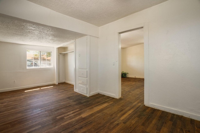 1601 7th St, Moriarty, NM 87035 - unfurnished bedroom featuring a textured ceiling, dark wood-style flooring, and a closet