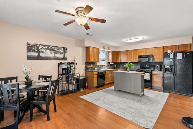 6404 Gambel Quail Rd NE, Rio Rancho, NM 87144 - kitchen with black appliances, tasteful backsplash, a ceiling fan, brown cabinetry, and light wood-style floors