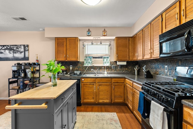 6404 Gambel Quail Rd NE, Rio Rancho, NM 87144 - kitchen featuring black appliances, butcher block countertops, wood finished floors, backsplash, and brown cabinetry