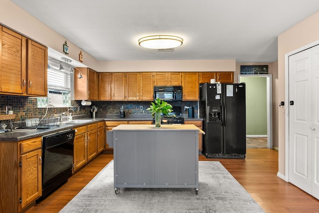 6404 Gambel Quail Rd NE, Rio Rancho, NM 87144 - kitchen with black appliances, tasteful backsplash, brown cabinetry, and dark wood finished floors