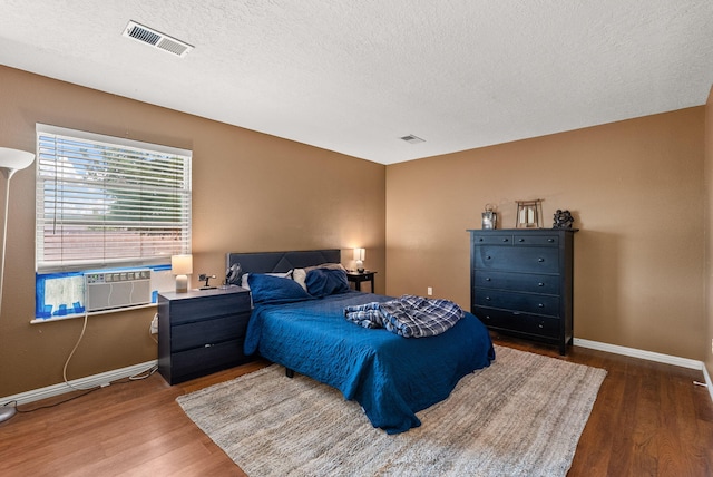 6404 Gambel Quail Rd NE, Rio Rancho, NM 87144 - bedroom with wood finished floors, a textured ceiling, and cooling unit